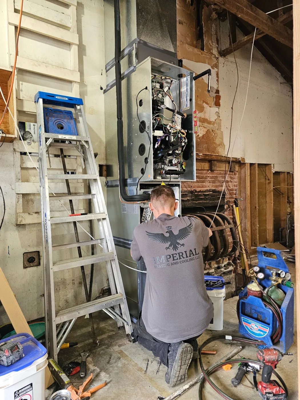 Imperial Heating and Cooling technician servicing a high-efficiency gas furnace and air handler in a Vancouver, WA home